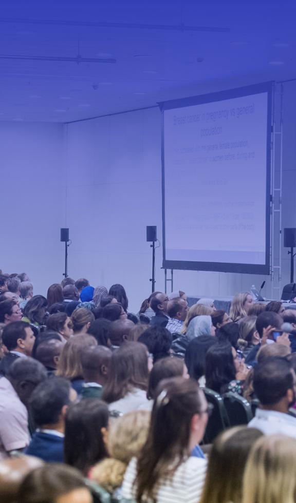 A conference room filled with a large crowd of people engaged in a discussion or presentation.